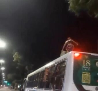 Homem é visto em cima de ônibus em movimento, em João Pessoa
