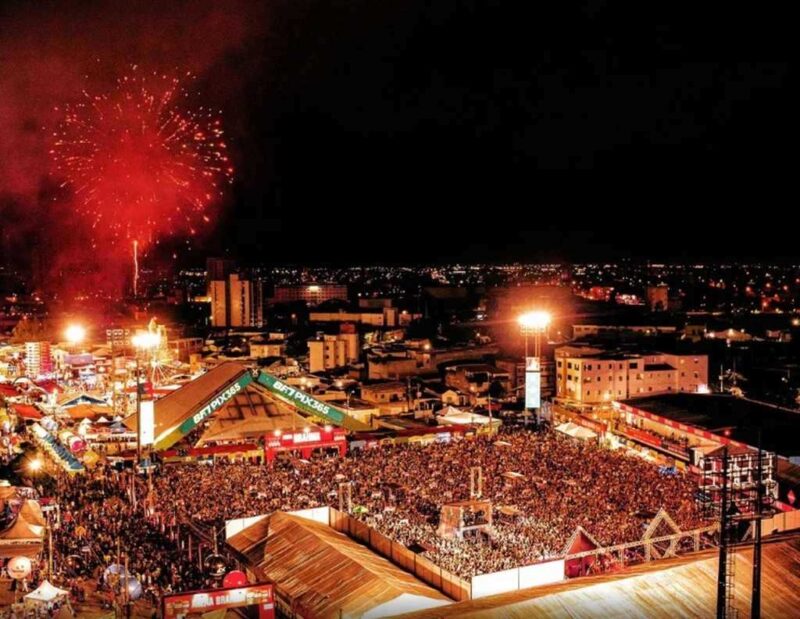 Campina Grande com uma grande multidão de pessoas e fogos de artifício no céu à noite, para celebrar a festa junina do dia de São João