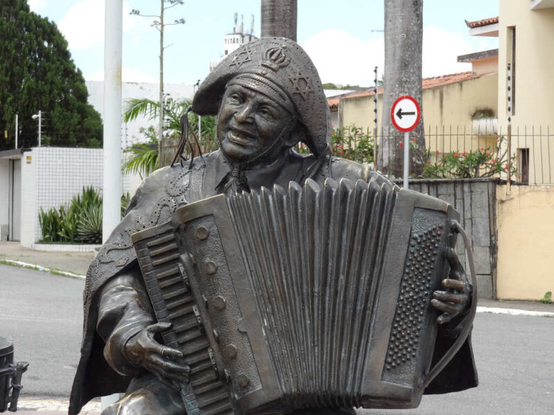 Estátua de Luiz Gonzaga com chapéu típico e tocando sanfona