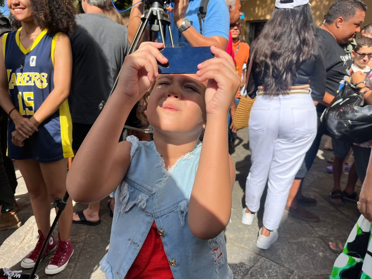 Criança observando eclipse solar anular em João Pessoa